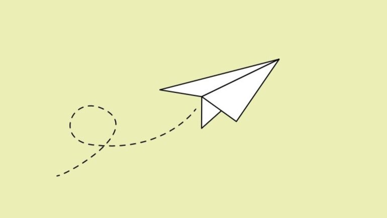 Weißer Papierflieger auf hellgrünem Hintergrund