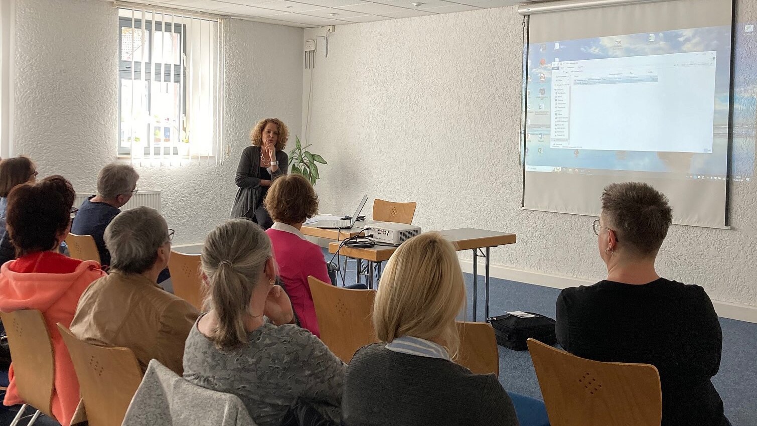 Foto: Simone Grecki-Runde hält vor einer Gruppe einen Vortrag