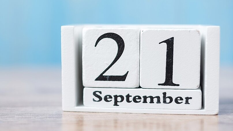 Weiße Holzklötzchen auf denen das Datum 21. September steht 
