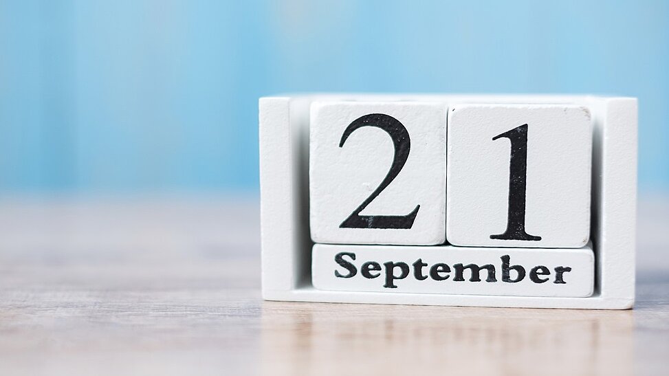 Weiße Holzklötzchen auf denen das Datum 21. September steht 