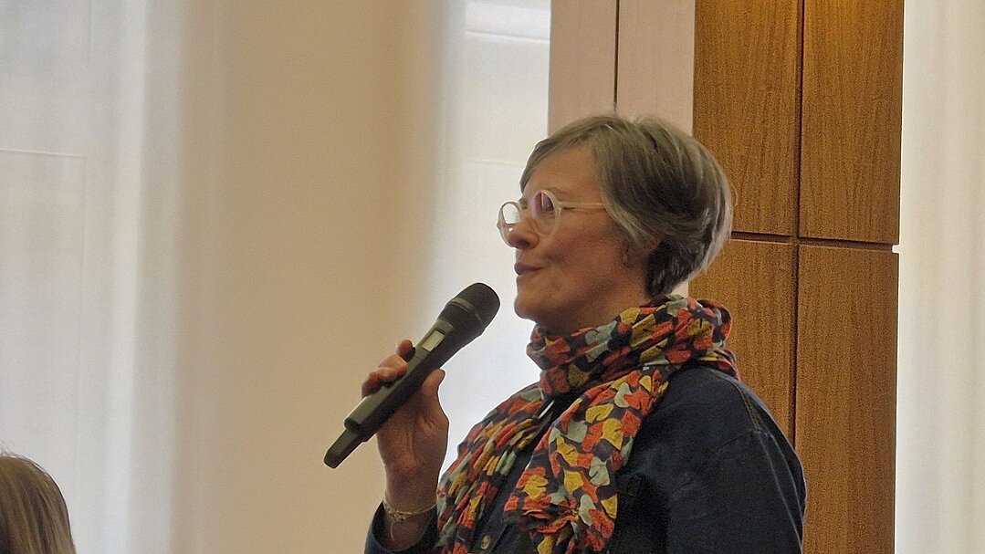 Seitenprofil einer älteren Frau, die in ein Mikrofon spricht