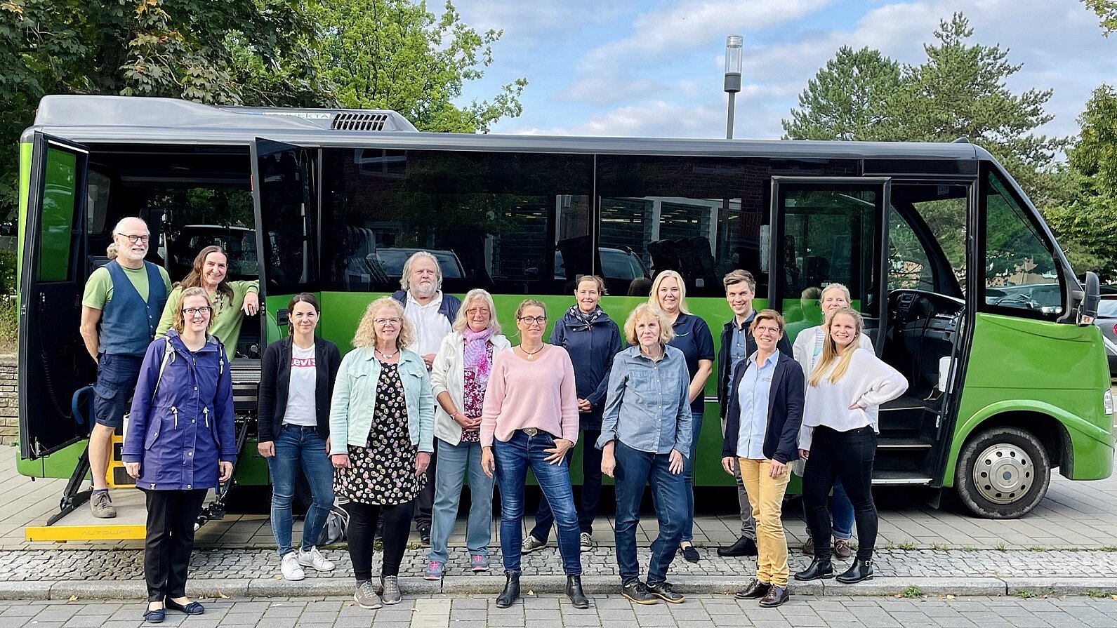 Team der Lokalen Allianz mit dem Bus75 Foto: Gruppenfoto mit 15 Männern und Frauen aus der Lokalen Allianz vor dem grünen Bus