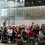 Blick ins Publikum: Die Teilnehmenden sitzen in Stuhlreihen