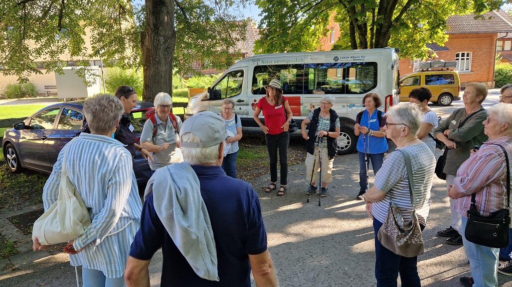 Eine Seniorengruppe bildet einen Kreis auf einem Parkplatz