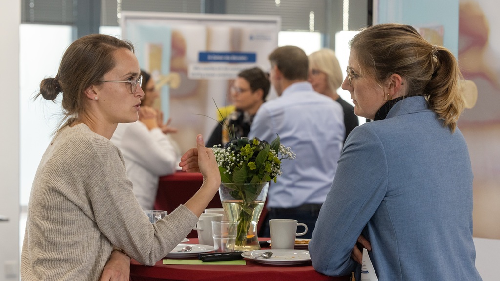Kaffeepause im Foyer Bild: Zwei Frauen unterhalten sich in der Pause am Stehtisch