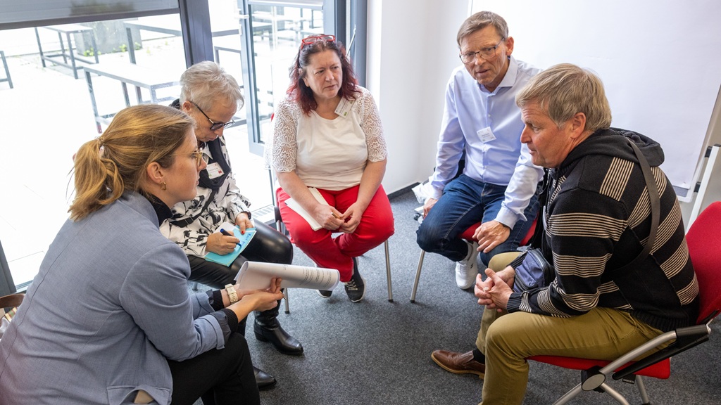 Gruppenarbeit im Workshop "Alle können mitwirken! – Ehrenamtliches Engagement von Menschen mit und ohne Demenz" Foto: Fünf Teilnehmende sitzen im Stuhlkreis und unterhalten sich