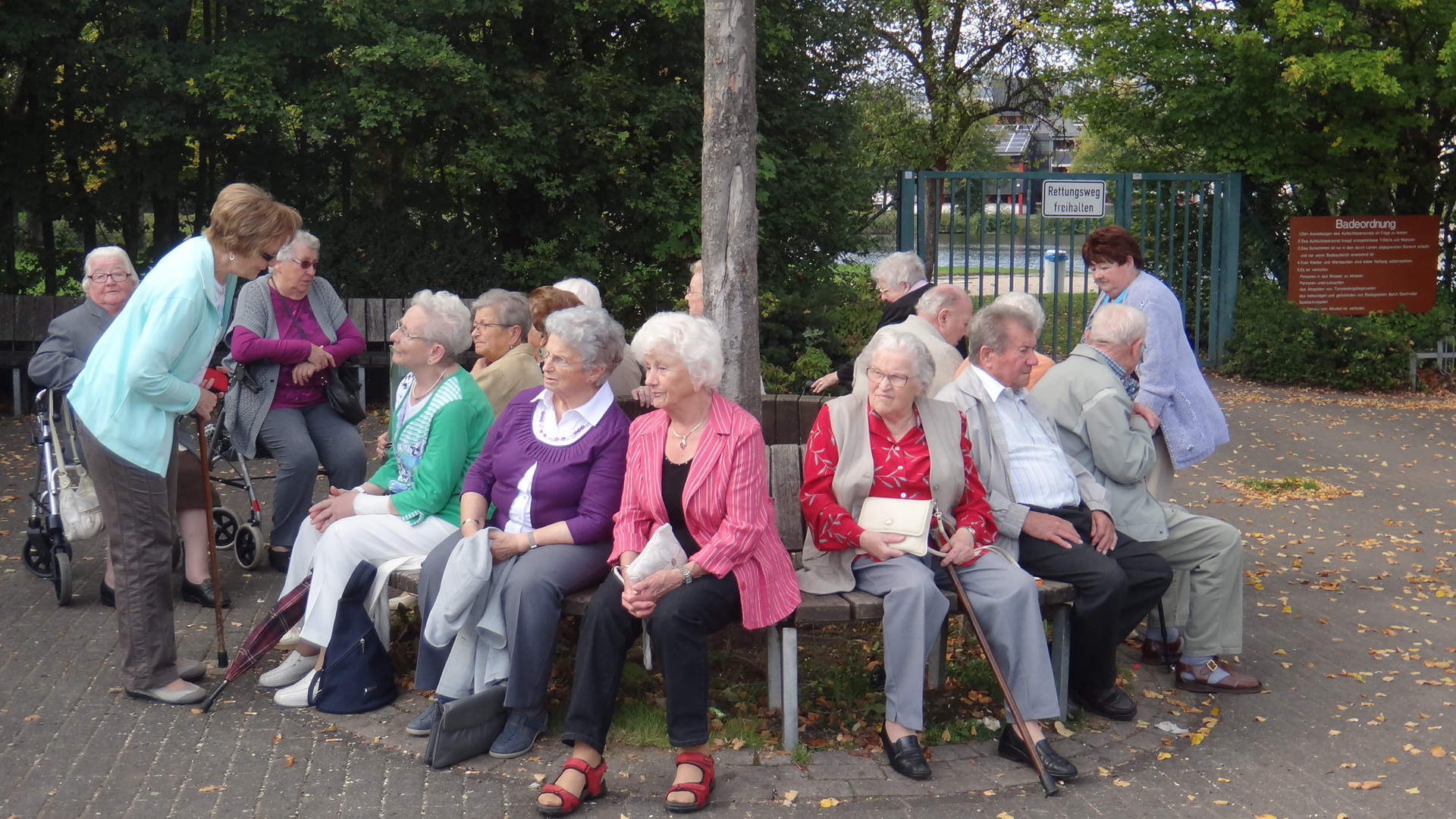 Eine Gruppe älterer Menschen sitzt auf einer Parkbank