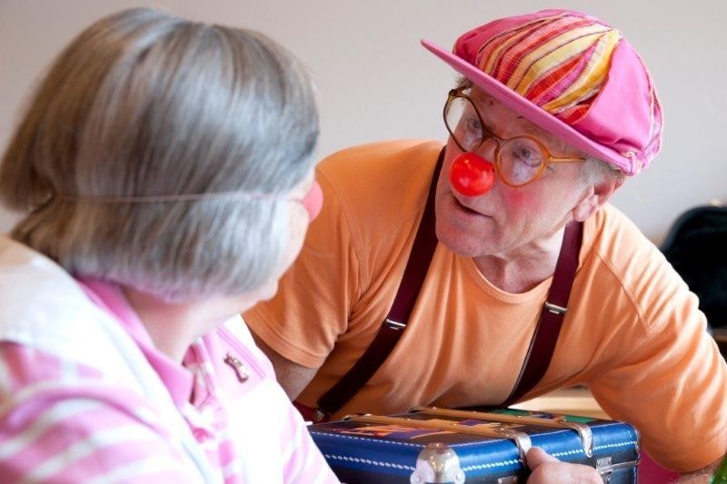 Ein Mann verkleidet als Clown und eine ältere Dame.